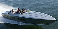 A fast High Performance boat with several people in it, traveling at swift speed accross the water